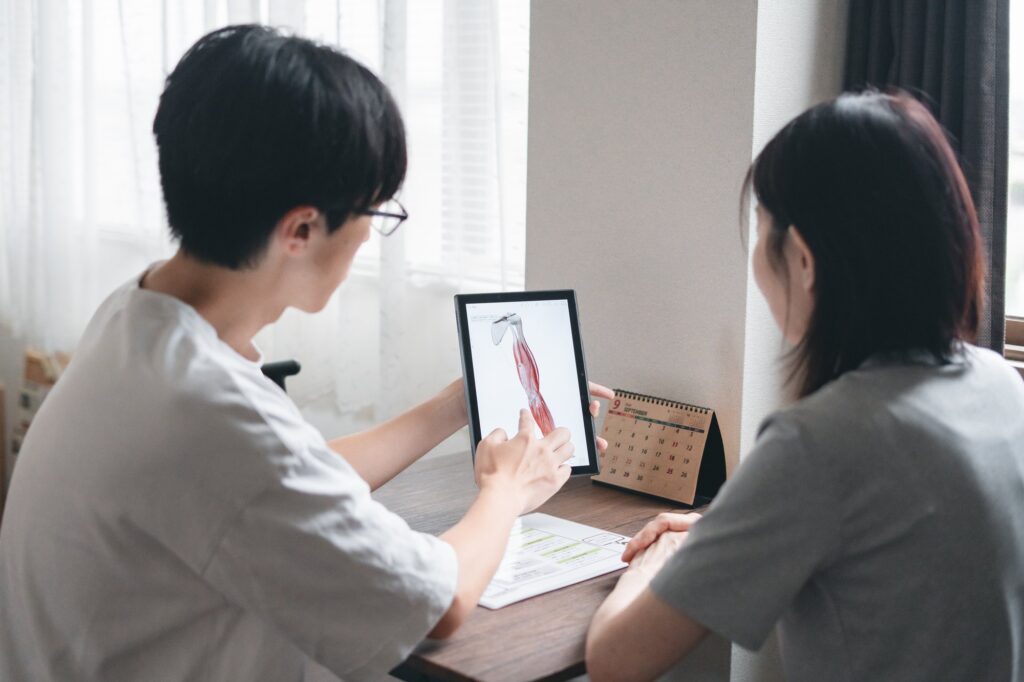 タブレットで体の図を見せながら説明している様子