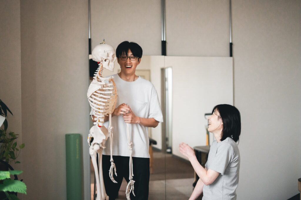 骨の模型を使って、笑顔で体のしくみを説明している様子