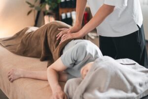 施術中の手元。タオルを敷いたベッドでの様子（寄り）