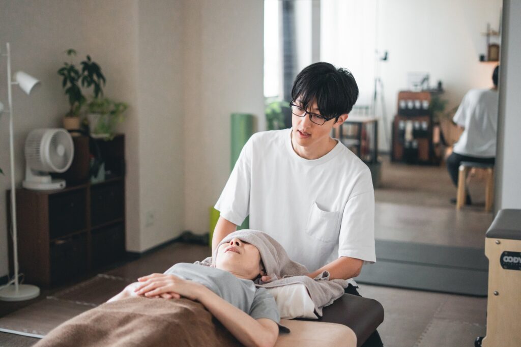 仰向けで首まわりを確認している施術の様子