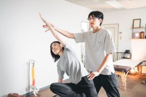 ピラティスのチェアを使った運動を、院長が横で見ている様子