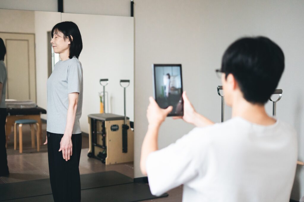 姿勢の写真を撮り、タブレットの画面で一緒に確認している様子