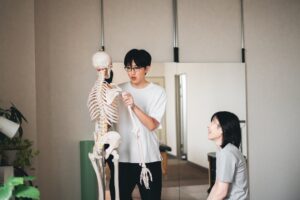 骨の模型を使って、笑顔で体のしくみを説明している様子