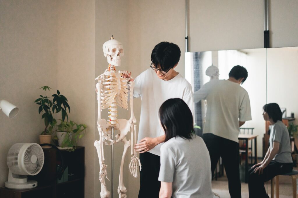 立った姿勢で、肩に手を当てて体の状態を確認している様子