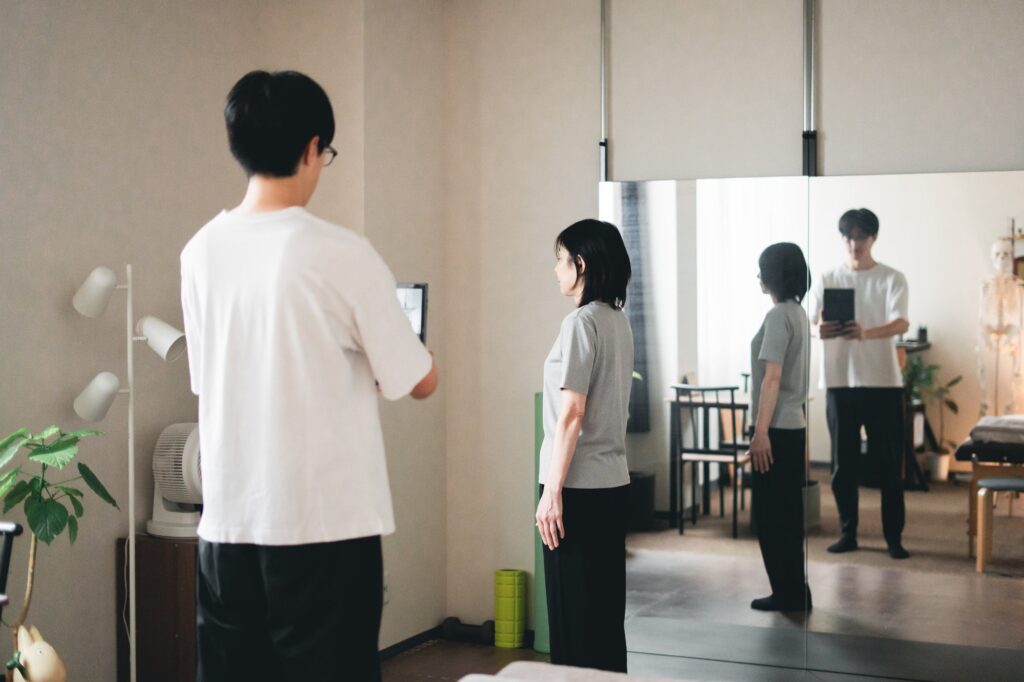 姿勢の写真を撮り、タブレットの画面で一緒に確認している様子