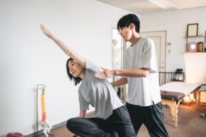 鏡のある部屋で、ピラティスのチェアを使って運動している様子