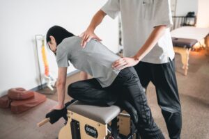 立った姿勢で、骨盤に手を当てて腰まわりを確認している様子